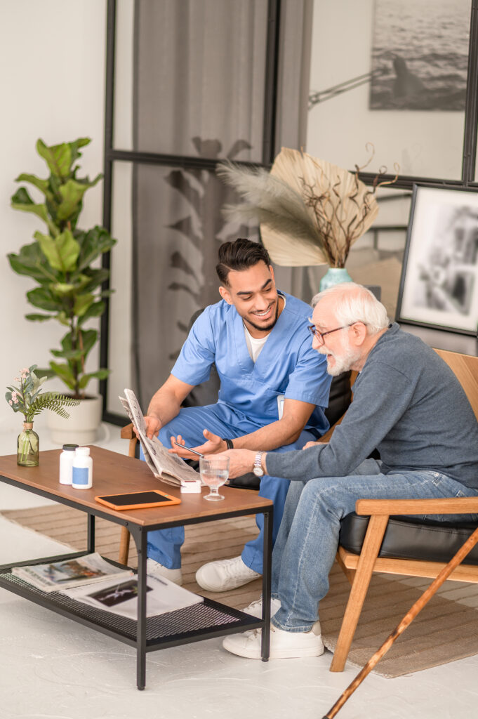 pensioner discussing news with his in home caretaker